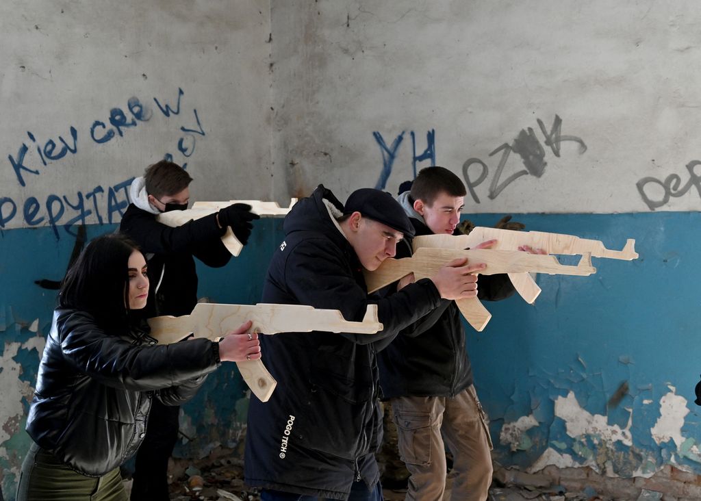  Sejumlah warga sipil memegang replika kayu senapan Kalashnikov ketika mengikuti latihan tempur warga sipil di sebuah pabrik yang terbengkalai di Kiev, Ukraina, Minggu (6/2/2022). Ratusan ribu warga Ukraina telah menjalani pelatihan tempur sejak beberapa bulan lalu, mempersiapkan diri membantu militer Ukraina menghadapi kemungkinan invasi Rusia ke negara tersebut. 