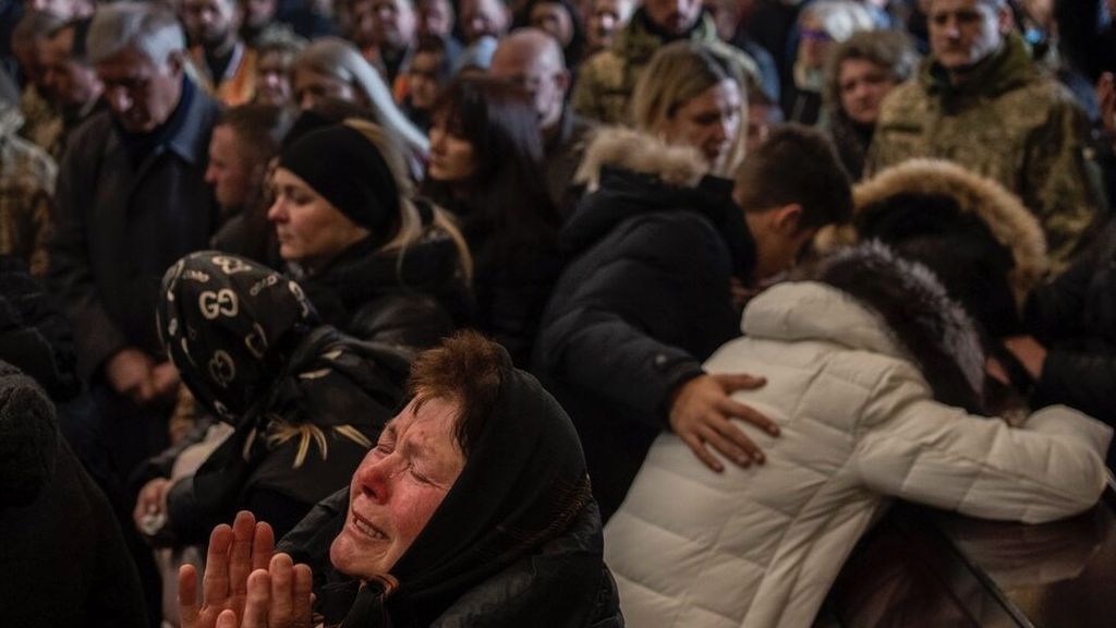 Para kerabat dan teman menghadiri upacara pemakaman untuk empat prajurit Ukraina yang tewas dalam serangan udara di pangkalan militer di Yarokiv, di sebuah gereja di Lviv, Ukraina, Selasa (15/3/2022). Selain personel militer, jumlah warga sipil yang tewas dalam perang di Ukraina juga terus bertambah. PPB mengonfirmasi sekitar 700 warga sipil tewas akibat perang, dengan jumlah sebenarnya kemungkinan lebih tinggi. 