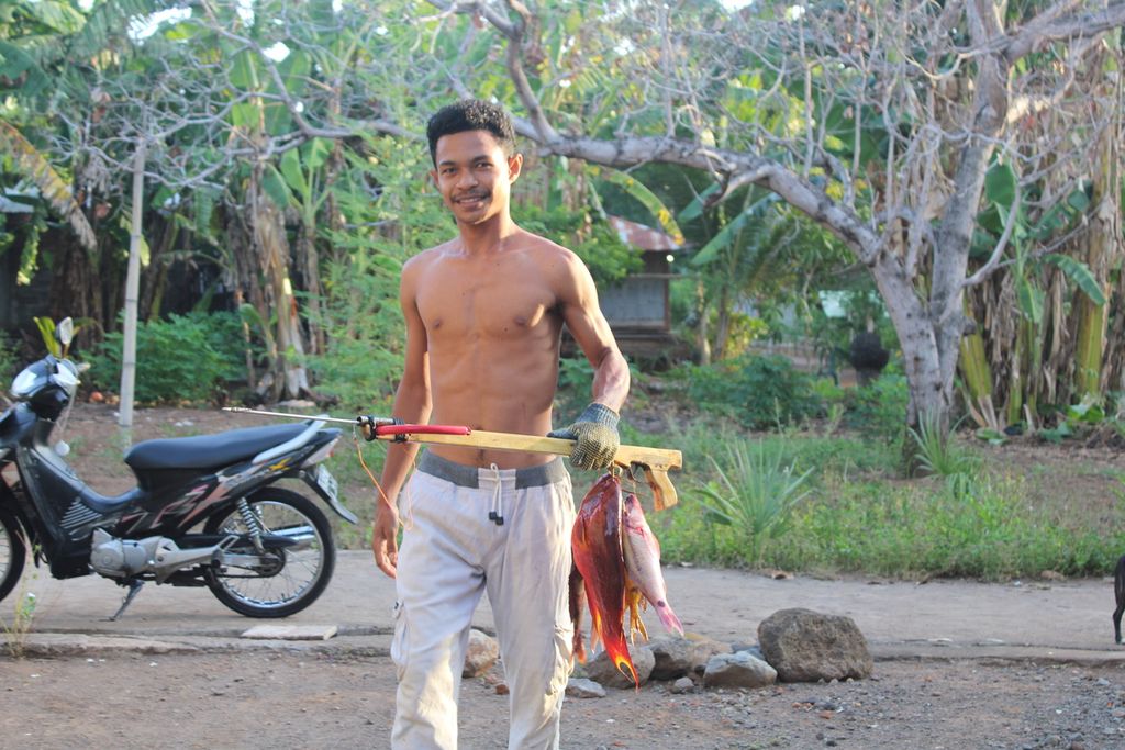 Warga pulang membawa ikan yang diambil dari perairan Desa Lewotobi, Kecamatan Ile Bura, Kabupaten Flores Timur, Nusa Tenggara Timur, pada Minggu (7/1/2024). 