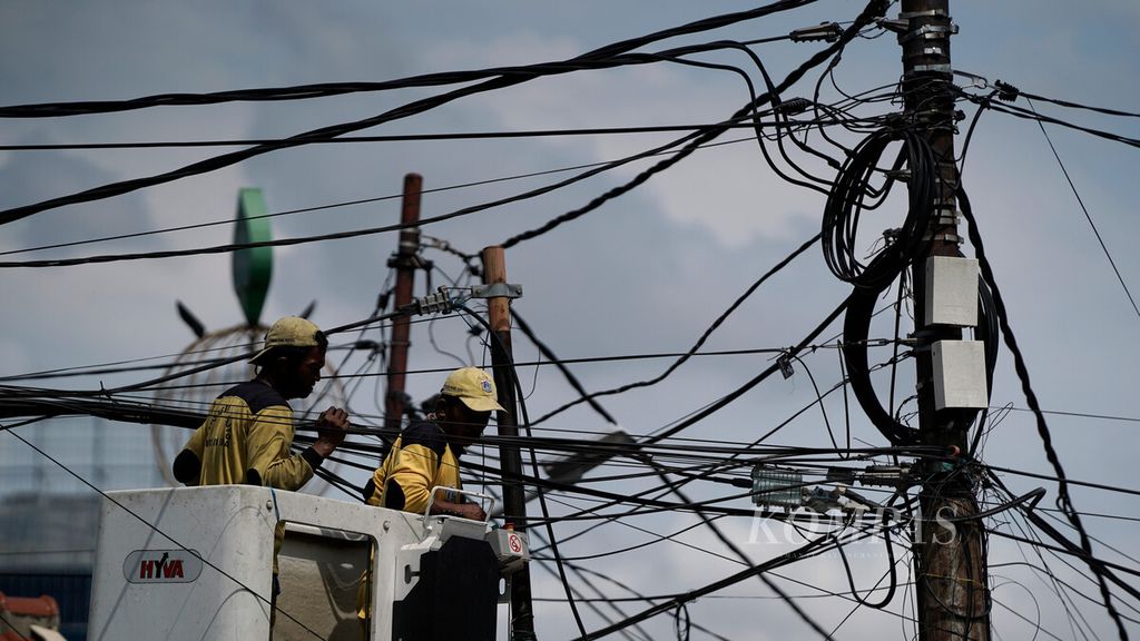 Satgas Pemeliharaan Simpang Jalan Tak Sebidang Dinas Bina Marga DKI Jakarta menata kabel udara di Jalan Mas Mansyur, Tanah Abang, Jakarta Pusat, Sabtu (21/11/2020). Kabel yang semrawut dan berantakan perlu ditata agar tidak membahayakan warga.