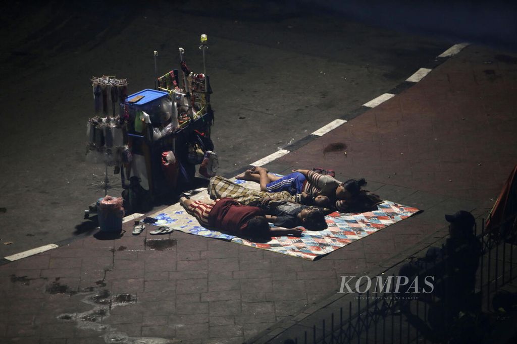 Sejumlah warga tidur di dekat gerobak dagangannya di bawah jalan layang Jalan Jati Baru Raya, Tanah Abang, Jakarta, Rabu (4/1/2023). 