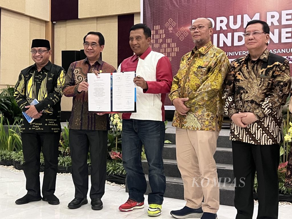 Rektor Universitas Hasanuddin Prof Dr Jamaluddin Jompa dan Ketua Forum Rektor Indonesia Prof Dr Nurhasan memegang lembar perjanjian kerja sama antarperguruan tinggi, Sabtu (3/2/2024), di Makassar.