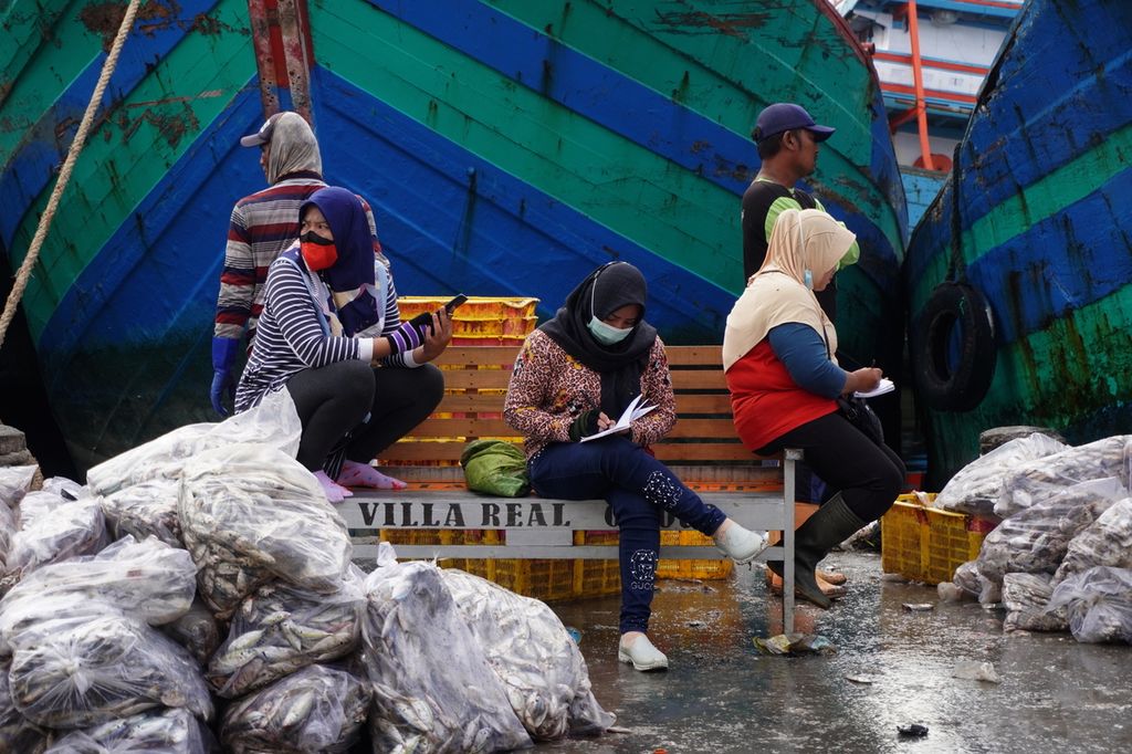 Para pengepul mencatat harga ikan yang mereka beli di Pelabuhan Perikanan Pantai Tegalsari, Kecamatan Tegal Barat, Kota Tegal, Jawa Tengah, Sabtu (14/8/2021) pagi. Setiap hari, paling tidak ada 30 kapal ikan berukuran di atas 30 gros ton yang bersadar dan membongkar muatannya di pelabuhan tersebut. Masing-masing kapal membawa hingga 40 ton ikan dari berbagai jenis.