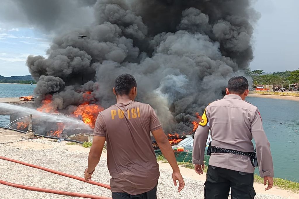 Petugas kepolisian berusaha memadamkan api yang membakar <i>speedboat</i> yang ditumpangi rombongan calon gubernur Maluku Utara Benny Laos di Dermaga Pelabuhan Regional Bobong, Desa Bobong, Kabupaten Pulau Taliabu, Maluku Utara, Sabtu (12/10/2024). 