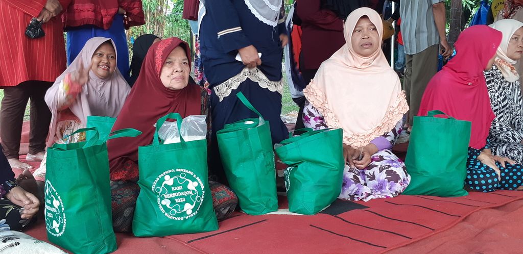 Sejumlah warga Sidoarjo menerima bantuan beras yang dibagikan oleh Komunitas Pekerja Jalanan, Minggu (16/4/2023).