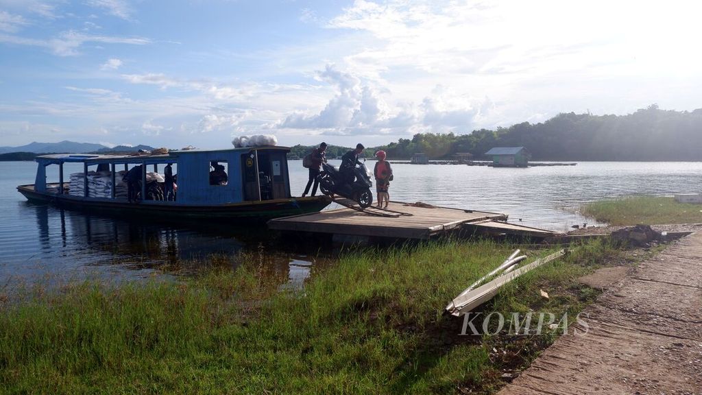 Warga menurunkan sepeda motor dari kapal di Dermaga Desa Benua Riam, Kecamatan Aranio, Kabupaten Banjar, Kalimantan Selatan, Jumat (27/5/2022). Akses utama menuju Benua Riam masih melalui Waduk Riam Kanan.
