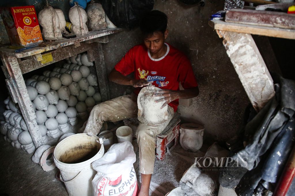 Daski perajin celengan tengah memproduksi celengan dari bahan semen gypsum di kecamatan Makassar, Jakarta Timur, Selasa (6/2/2024). Usaha mikro, kecil, dan menengah (UMKM) yang dimulai sejak tahun 2007 ini belum tersentuh teknologi informasi untuk memasarkan produknya secara daring.  