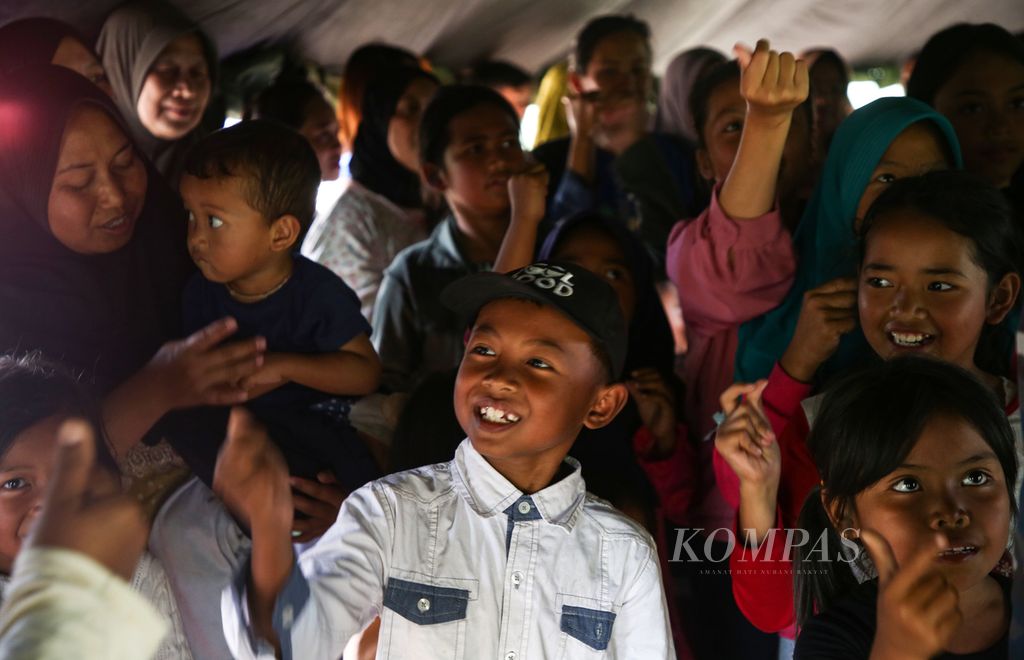 Ekspresi anak-anak saat mengikuti permainan dalam program pemulihan trauma bagi korban gempa bumi di Desa Pakuon, Kecamatan Sukaresmi, Kabupaten Cianjur, Jawa Barat, Minggu (27/11/2022). Kegiatan tersebut disambut dengan antusias oleh anak-anak korban gempa.