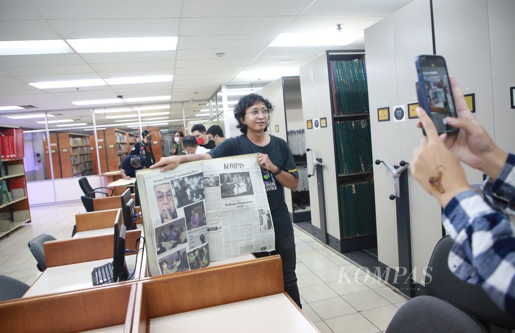 Prasajadi, kolektor non-fungible token (NFT) harian <i>Kompas</i>, berfoto dengan koran harian <i>Kompas</i> yang dikoleksinya dalam bentuk NFT saat berkunjung ke Pusat Informasi Kompas di Jakarta, Selasa (6/9/2022). Para kolektor #NFTKompas ini berkesempatan untuk bertemu dan mengetahui lebih jauh terkait proses pengarsipan koran dan rapat redaksi untuk menentukan berita di harian Kompas.