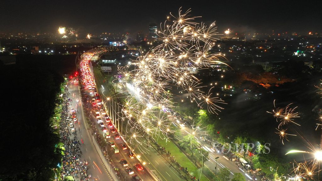Warga merayakan pergantian tahun dengan menyalakan kembang api di Jalan Ahmad Yani, Kota Bekasi, Jawa Barat, Minggu (1/1/2023). 