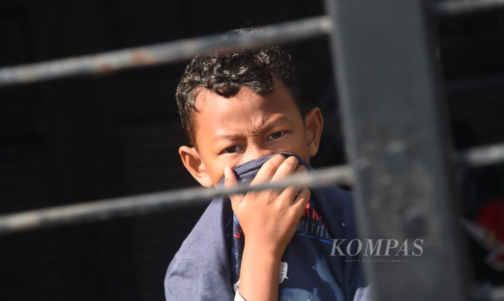 Seorang anak menutup hidungnya saat petugas melakukan <i>fogging</i> di kompleks perumahan Deltasari Indah, kecamatan Waru , Kabupaten Sidoarjo, Minggu (13/6/2021). 