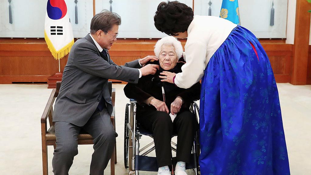 Presiden Korea Selatan Moon Jae-in dan Ibu Negara Kim Jung-suk, Kamis (4/1), menyapa seorang wanita Korea Selatan yang dipaksa bekerja sebagai wanita penghibur di rumah bordil pada masa pendudukan Jepang. Pertemuan itu digelar di Gedung Biru, Seoul. 