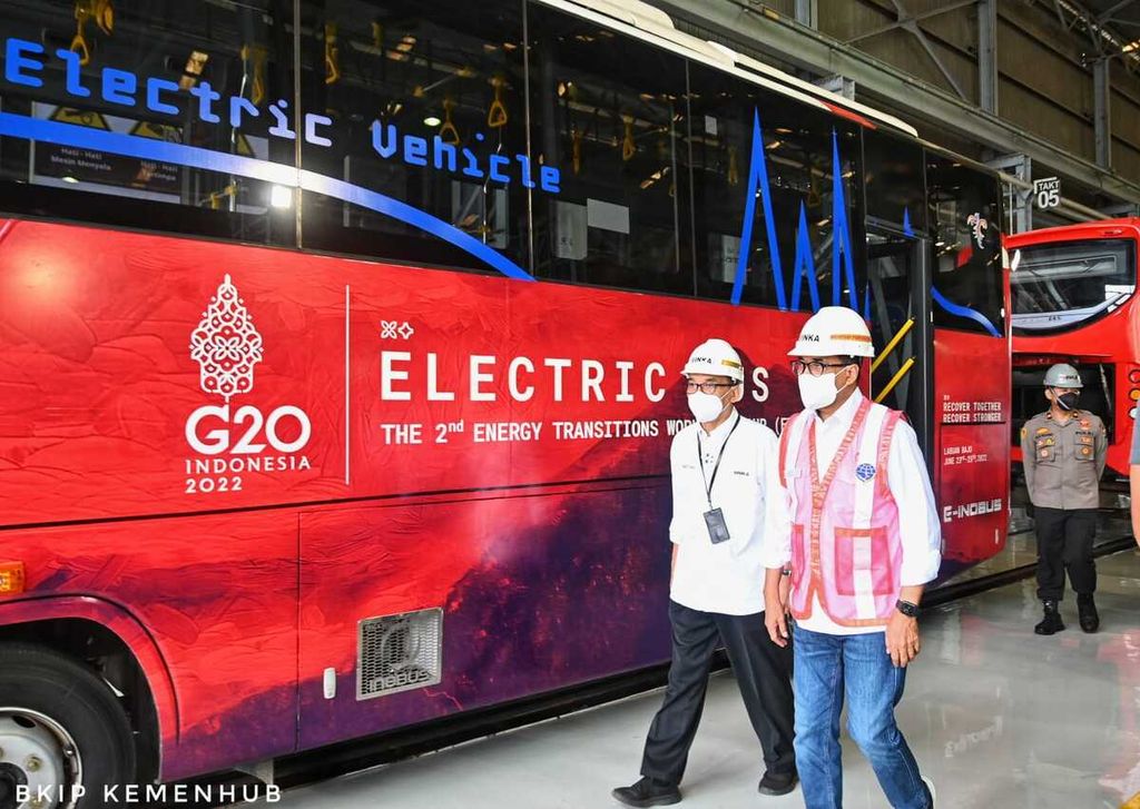 Bus listrik buatan PT INKA (Persero) ditinjau langsung oleh Menteri Perhubungan Budi Karya Sumadi (kanan) mengenakan rompi merah di Pabrik PT INKA, Madiun, Jawa Timur, Minggu (17/7/2022). Bus listrik ini diproduksi untuk acara G20 di Bali pada November 2022. 