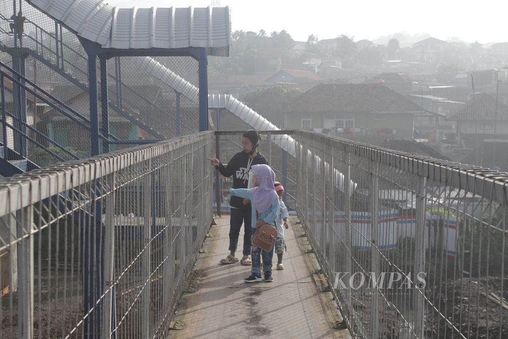 Sejumlah anak beserta pendampingnya mengamati petugas yang bekerja di tengah konstruksi bangunan stasiun konektivitas Kereta Cepat Jakarta-Bandung di Stasiun Padalarang, Kabupaten Bandung Barat, Jawa Barat, Senin (12/4/2021).