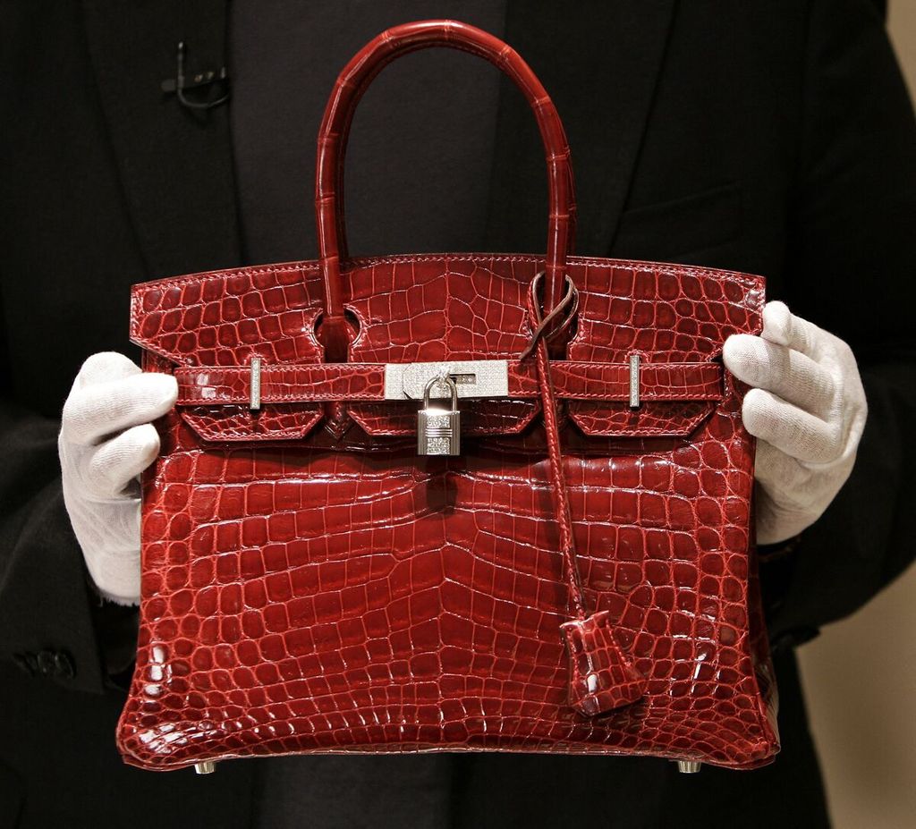 An employee holds a $129,000 US dollar Hermes bag made of crocodile leather, which is equivalent to Rp 2 billion, to be shown to the media during the opening of a new Hermes store on Wall Street, New York, USA on June 21, 2007.