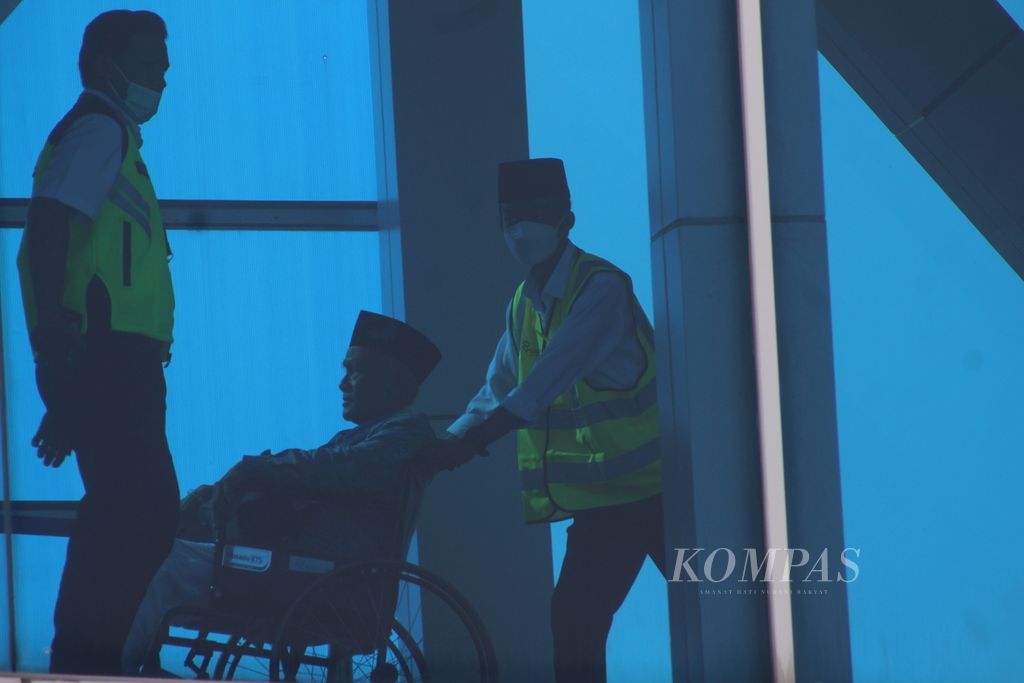 Petugas di Bandara Sultan Mahmud Badaruddin II Palembang mendorong seorang calon jemaah haji kloter pertama dari embarkasi Palembang menggunakan kursi roda. 