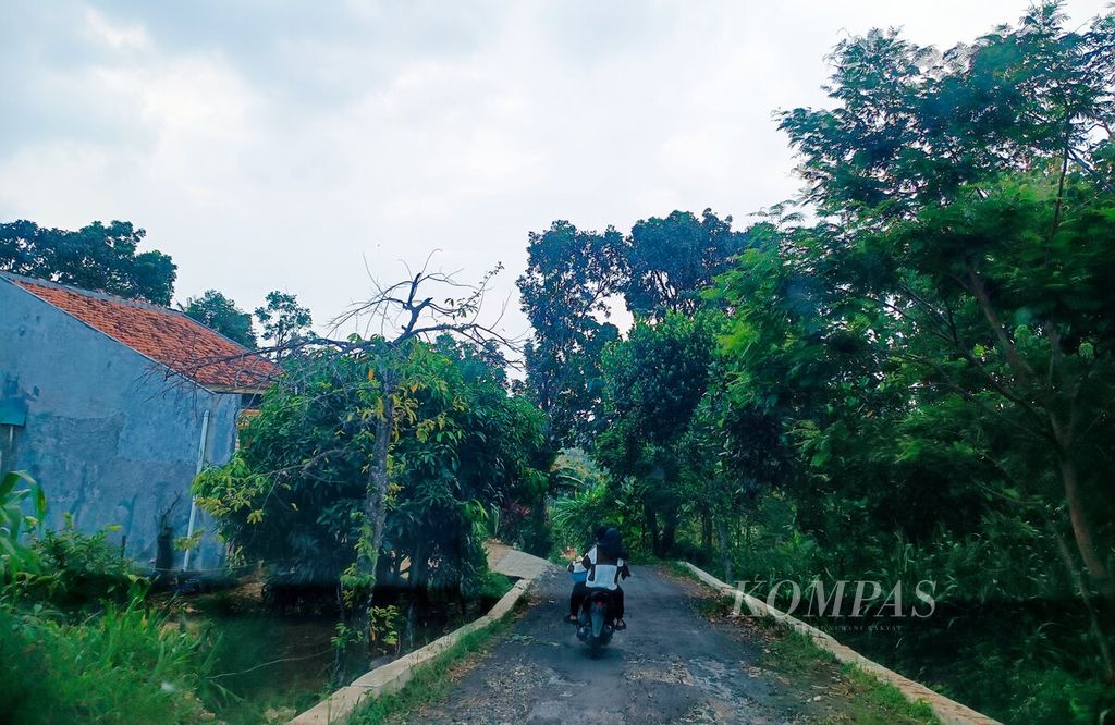 Warga melintasi Desa Sumbersoko yang menjadi area pengeroyokan massa beberapa hari sebelumnya di Kecamatan Sukolilo, Kabupaten Pati, Jawa Tengah, Rabu (12/6/2024).