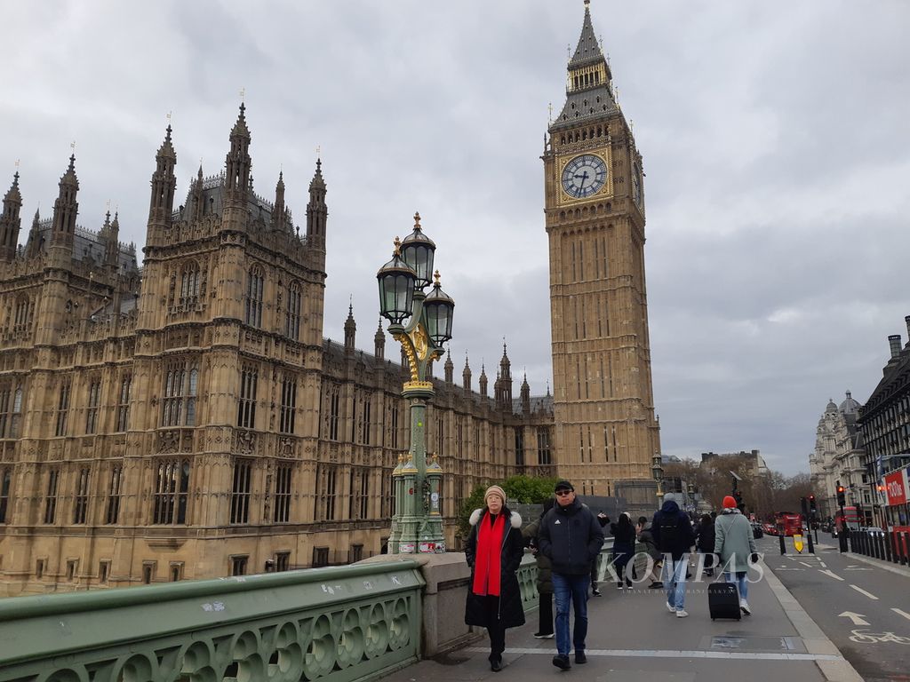 Wisatawan melintas di dekat Big Ben London, Inggris, pada Minggu (26/11/2023). Mereka berpose dengan latar belakang bangunan ikonik itu. London baru saja menggelar pemilu wali kota, menghasilkan petahana Shadiq Khan sebagai wali kota terpilih untuk ketiga kalinya.  