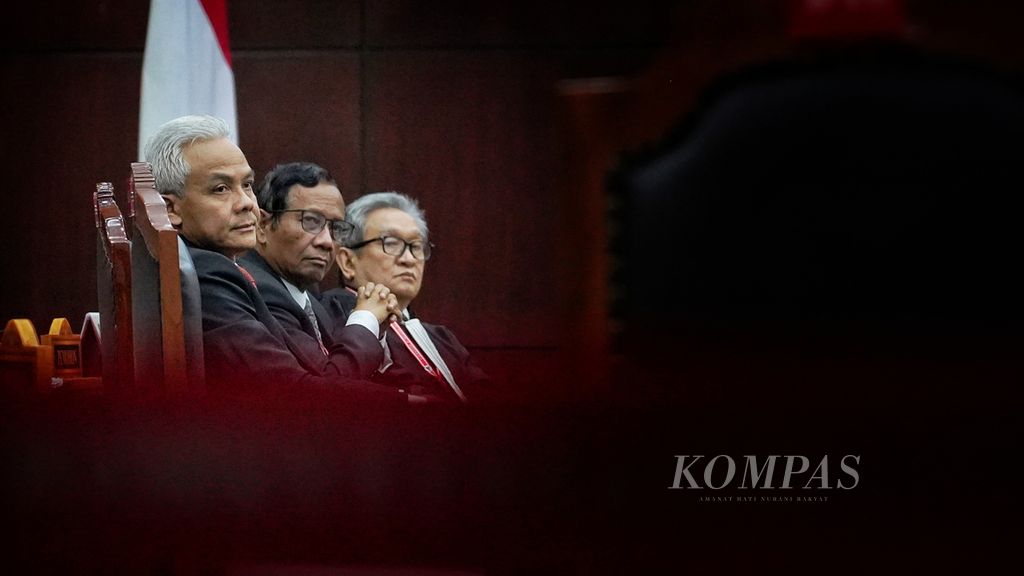 Pemohon capres dan cawapres Ganjar Pranowo (kiri) dan Mahfud MD (tengah) duduk bersama salah satu anggota kuasa hukum pemohon, Maqdir Ismail (kanan), pada sidang pendahuluan perkara Perselisihan Hasil Pemilihan Umum (PHPU) Pemilihan Presiden dalam Pemilu 2024 di Mahkamah Konstitusi, Jakarta, Rabu (27/3/2024). 