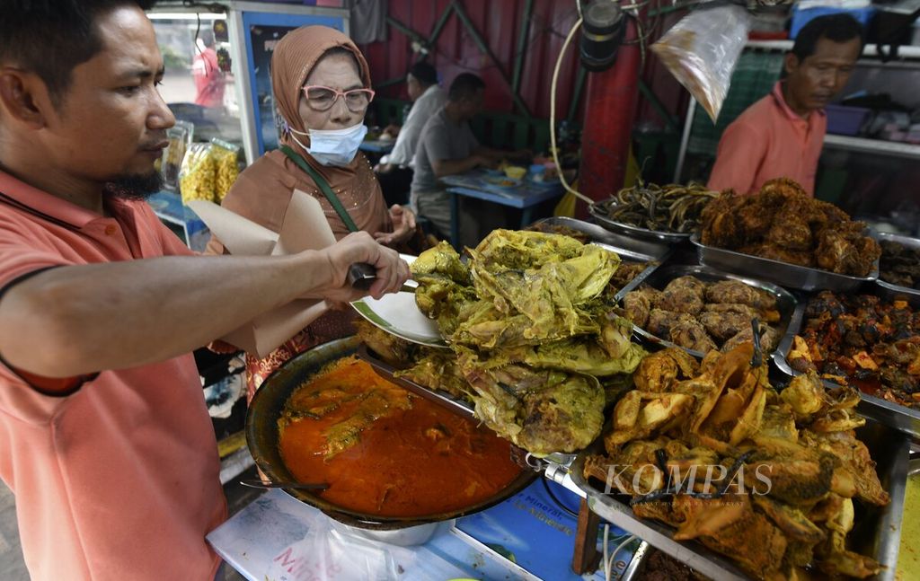 Pelanggan memesan gulai kepala ikan di kedai nasi kapau Uni Upik di Jalan Kramat Raya, Senen, Jakarta Pusat, Jumat (2/12/2022). 