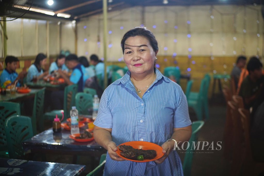 Serly Sumual (54), pemilik Rumah Makan Chit Chat di Manado, Sulawesi Utara, Sabtu (9/12/2023). Meski menyediakan berbagai jenis ikan, spesialisasi rumah makan yang didirikan pada 2016 tersebut adalah rahang tuna bakar.