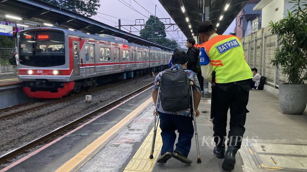 Penyandang disabilitas dibantu petugas stasiun untuk mengakses kereta rel listrik (KRL) di Stasiun Cawang, Jakarta pada Jumat (26/5/2023). 