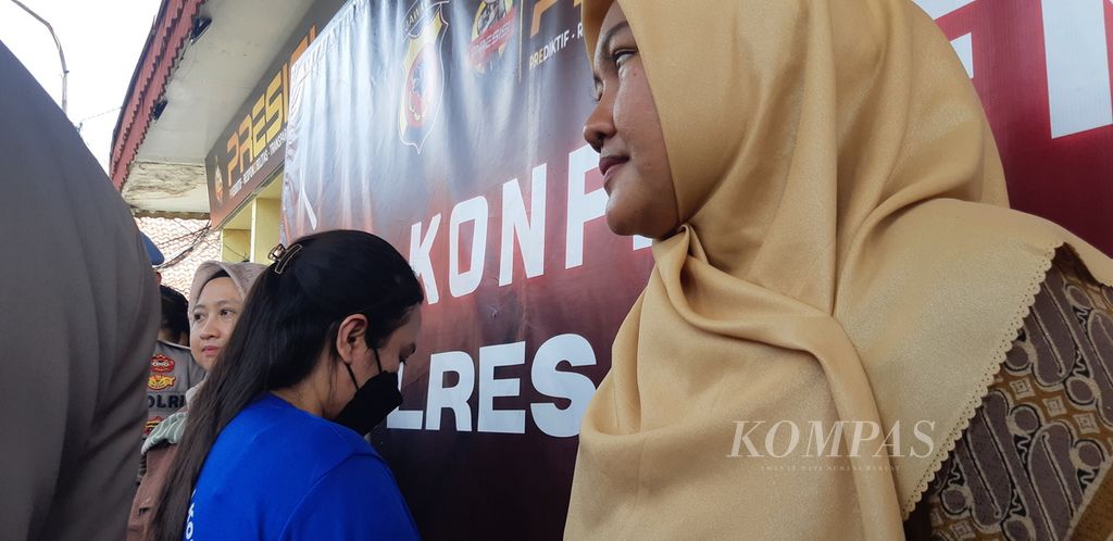 NP (mengenakan baju tahanan berwarna biru) menunduk saat konferensi pers di Markas Kepolisian Resor Cirebon Kota, Jawa Barat, Jumat (12/1/2024). Ibu rumah tangga itu menjadi tersangka kasus penipuan jual beli tanah. Para korbannya mengalami kerugian hingga Rp 10 miliar.