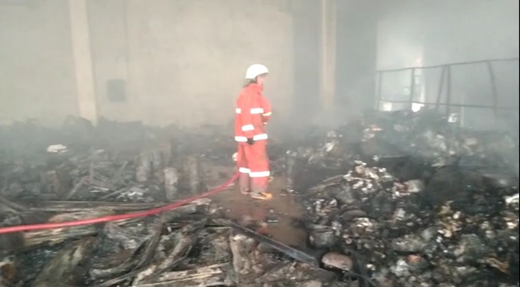 Petugas pemadam kebakaran menyisir bagian dalam bangunan yang terbakar di gudang JNE di Jalan Perkapuran, Kelurahan Curug, Kecamatan Cimanggis, Depok, Jawa Barat, Senin (12/9/2022) pagi.