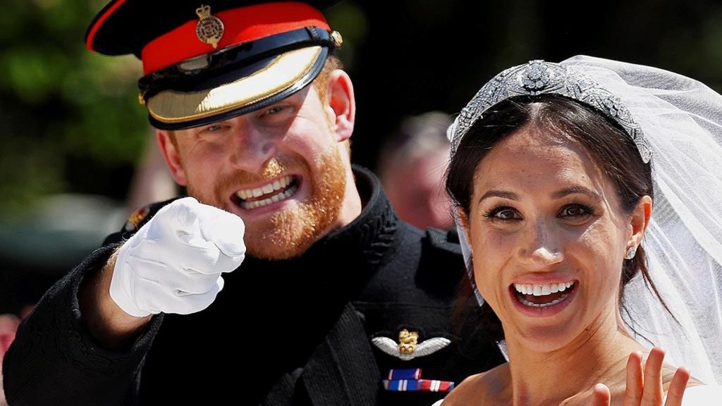 Ekspresi kegembiraan pasangan pengantin Pangeran Harry dan Meghan Markle, dari atas kereta kuda yang mereka naiki seusai upacara pernikahan mereka di Kapel St George, Kastel Windsor, Windsor, Inggris, Sabtu (19/5/2018).