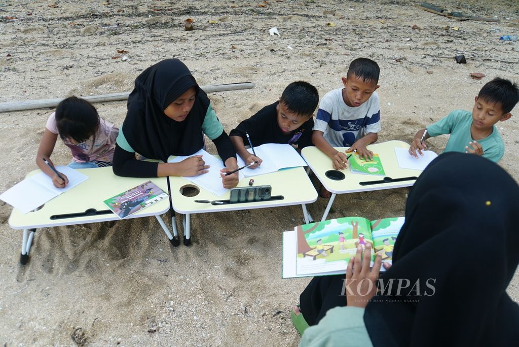 Anak-anak yang sudah mampu membaca dan menulis mengikuti kelas informal baca-tulis yang diselenggarakan komunitas literasi bernama Aksara Manado, Sabtu (18/11/2023), di Pulau Bunaken, Manado, Sulawesi Utara. 