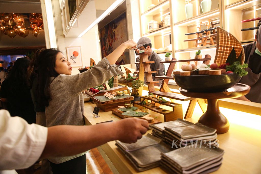 Pengunjung mengambil sushi yang disajikan Art Cafe, Hotel Rafles Jakarta, Selasa (23/3/2023).