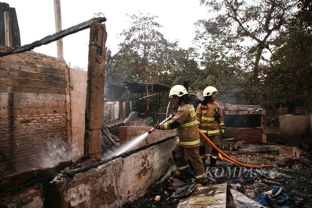 Petugas pemadam kebakaran melakukan pendinginan di lokasi kebakaran di kawasan Manggarai, Tebet, Jakarta Selatan, Sabtu (17/12/2022). Kebakaran tersebut menghanguskan sekitar 50 rumah semipermanen yang berada di bantaran Sungai Ciliwung.