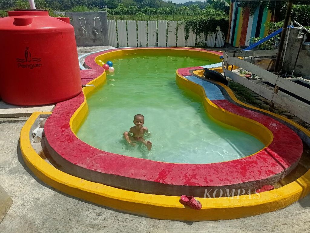Seorang anak tampak berenang di kolam renang yang disediakan di area <i>mini zoo </i>di Balkondes Wanurejo, Kecamatan Borobudur, Kabupaten Magelang, Jawa Tengah, Minggu (1/5/2022).