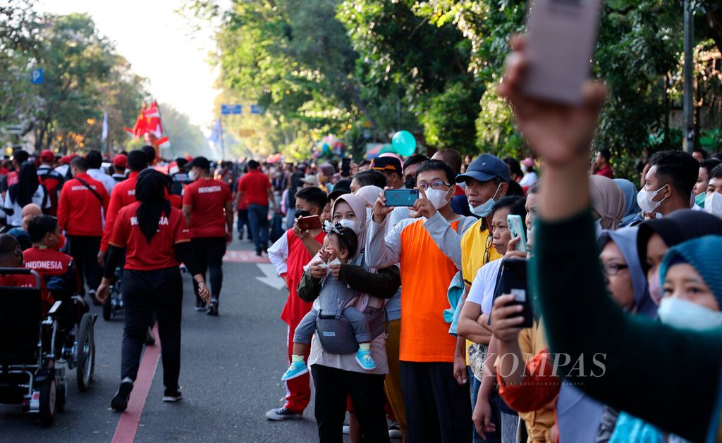 Residents watch and capture the 2022 ASEAN Para Games torch relay at Sriwedari Stadium, Surakarta City, Central Java, Sunday (24/7/2022). The city of Surakarta has twice hosted the ASEAN Para Games.
