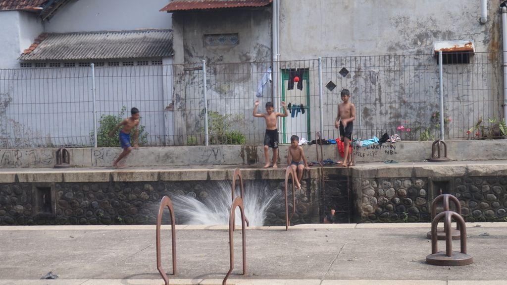 Anak-anak kampung bergembira dengan bermain di Sluis Wonokromo, bagian dari kompleks Pintu Air Wonokromo, Surabaya, Jawa Timur, Minggu (19/3/2023). Prasarana pengairan itu dibangun di masa Hindia-Belanda dalam kurun 1865-1889 untuk pengendali banjir Kali Surabaya, penyedia air baku dari Kali Surabaya, penahan intrusi air laut dari Selat Madura, dan jalur transportasi untuk perahu.