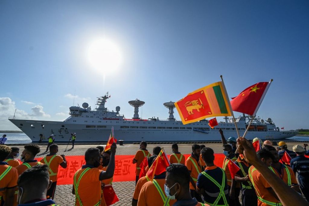 Para pekerja pelabuhan mengibarkan bendera nasional China dan Sri Lanka untuk menyambut kedatangan kapal peneliti dan survei militer China, Yuan Wang 5, di Pelabuhan Hambantota, Sri Lanka, Selasa, 16 Agustus 2022. 