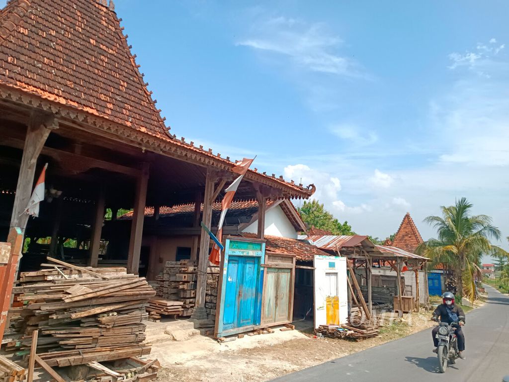 Warga melintasi deretan sentra pedagang kayu bekas rumah di Kecamatan Sukolilo, Kabupaten Pati, Jawa Tengah, Kamis (13/6/2024).