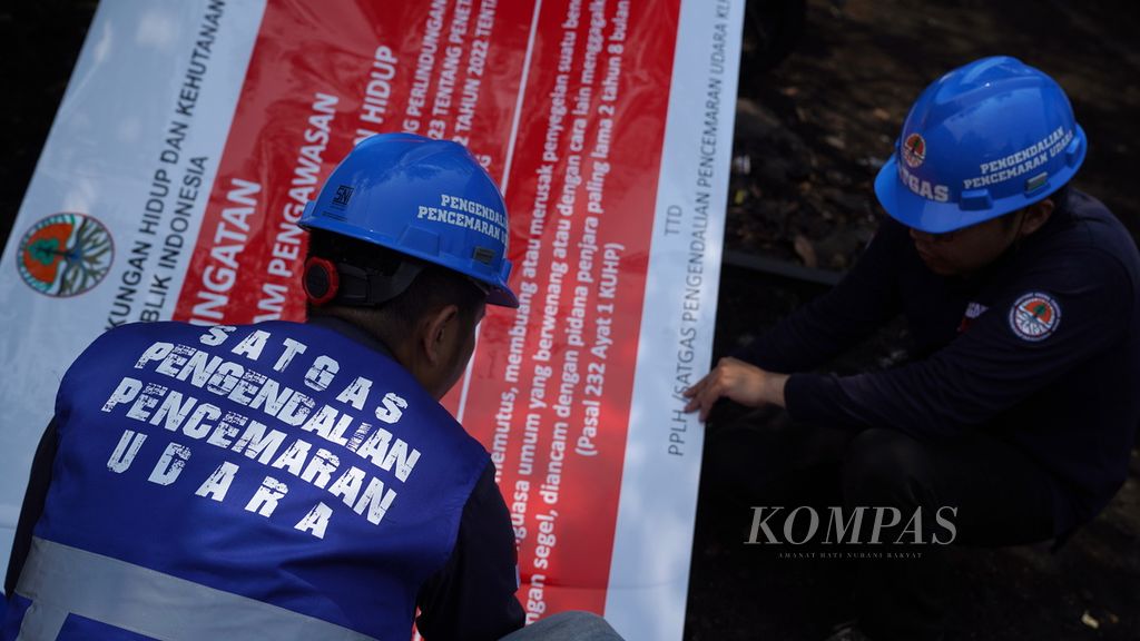 Satgas Pengendalian Pencemaran Udara Kementerian Lingkungan Hidup dan Kehutanan (KLHK) bersiap memasang papan area dalam pengawasan di sebuah <i>stockpile </i>batubara atau tempat penumpukan batubara di Jalan Cakung Cilincing Raya, Cakung, Jakarta Timur, Kamis (31/8/2023). 
