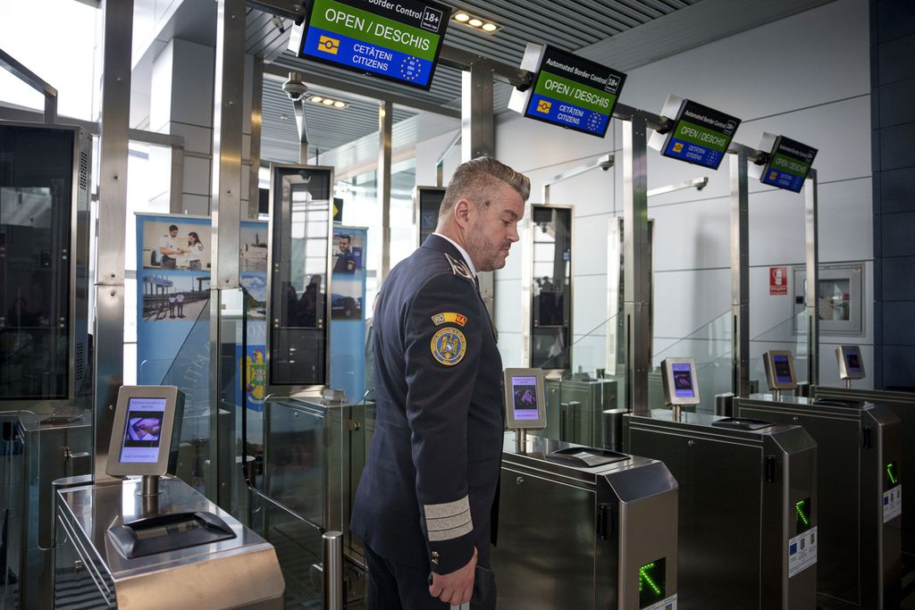 Seorang polisi berdiri di dekat pintu perbatasan otomatis Non-Schengen di Bandar Udara Internasional Henri Coanda di Otopeni, dekat Bucharest, Romania, 28 Maret 2024. 
