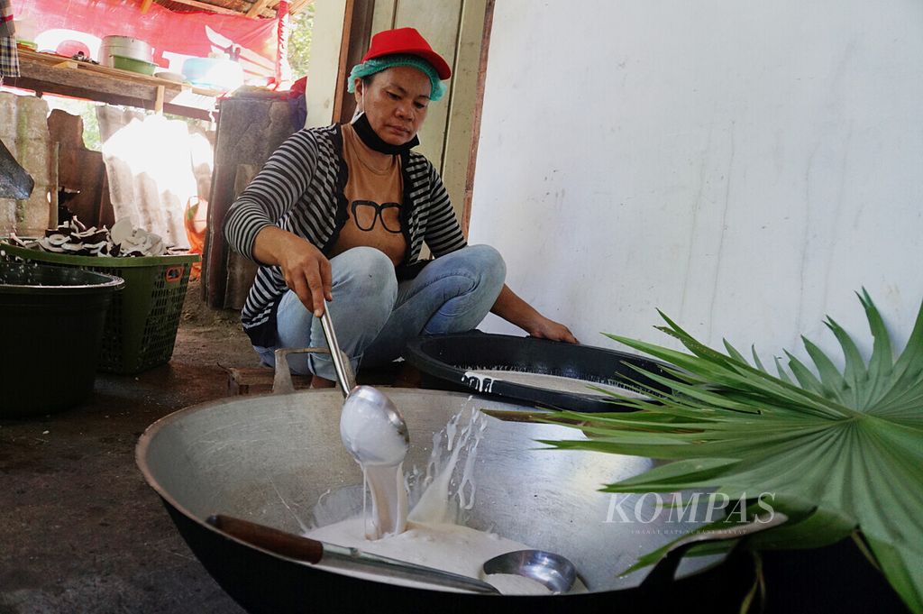 Anggota kelompok tani Ezer Keneg’do memindahkan santan kental ke wajan sebelum diolah menjadi minyak kelapa, Kamis (16/4/2020), di unit pengolahan minyak kelapa Desa Jayakarsa, Likupang Barat, Minahasa Utara, Sulawesi Utara.