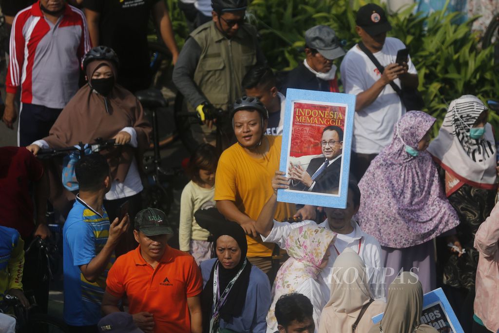 Warga menunggu kedatangan Gubernur DKI Jakarta Anies Baswedan sambil membawa poster dukungan terhadap Anies saat hari bebas kendaraan bermotor di kawasan Bundaran Hotel Indonesia, Jakarta, Minggu (16/10/2022). 