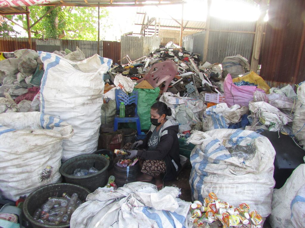 Seorang karyawan Bank Sampah Mutiara Timor memilah sampah yang menumpuk, di Kupang, Kamis (29/9/2022).