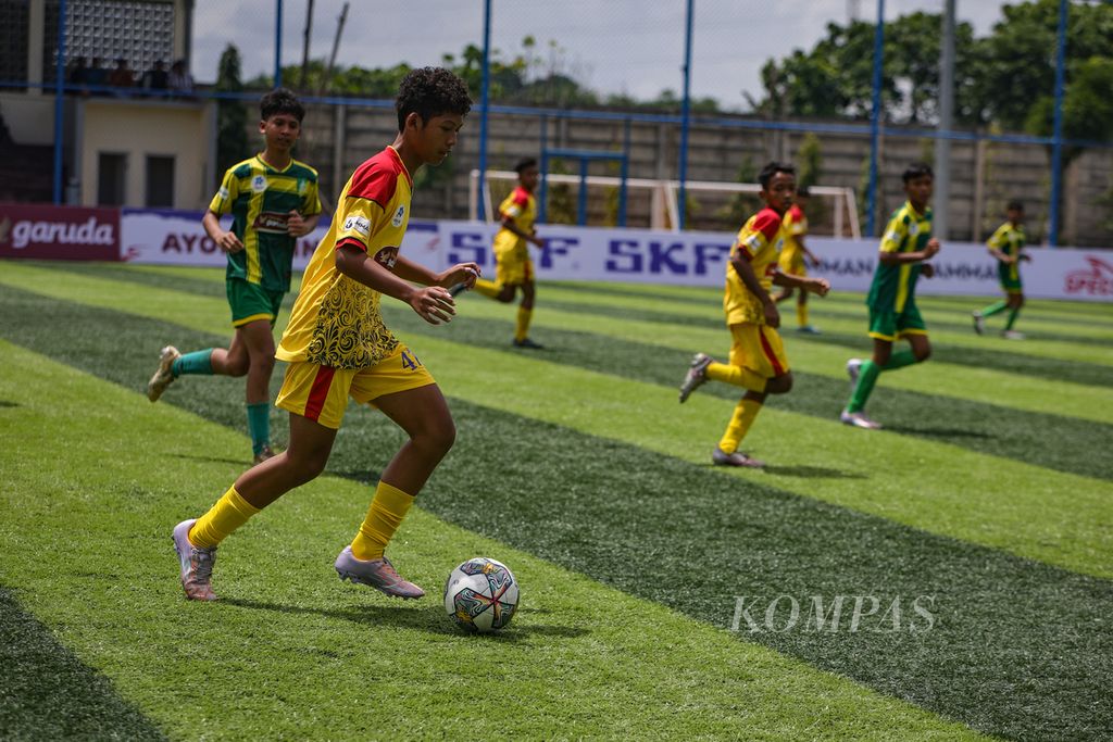Pemain Salfas Soccer, Raihan Budi Saputra, menggiring bola saat melawan Siaga Pratama dalam laga pekan kesembilan Liga Kompas Kacang Garuda U-14 di Dewantara Sport Center, Tangerang Selatan, Banten, Minggu (21/1/2024). 