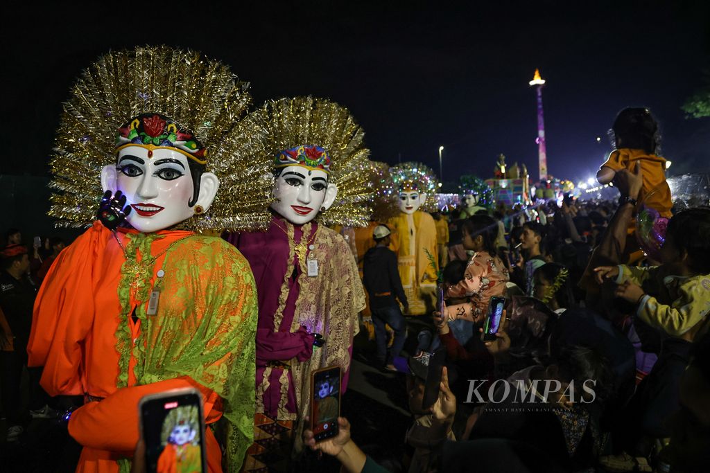 Ondel-ondel meramaikan pawai Jakarnaval di kawasan Monas, Jakarta, Minggu (31/12/2023). Warga memadati kawasan Monas untuk merayakan malam Tahun Baru 2024. 