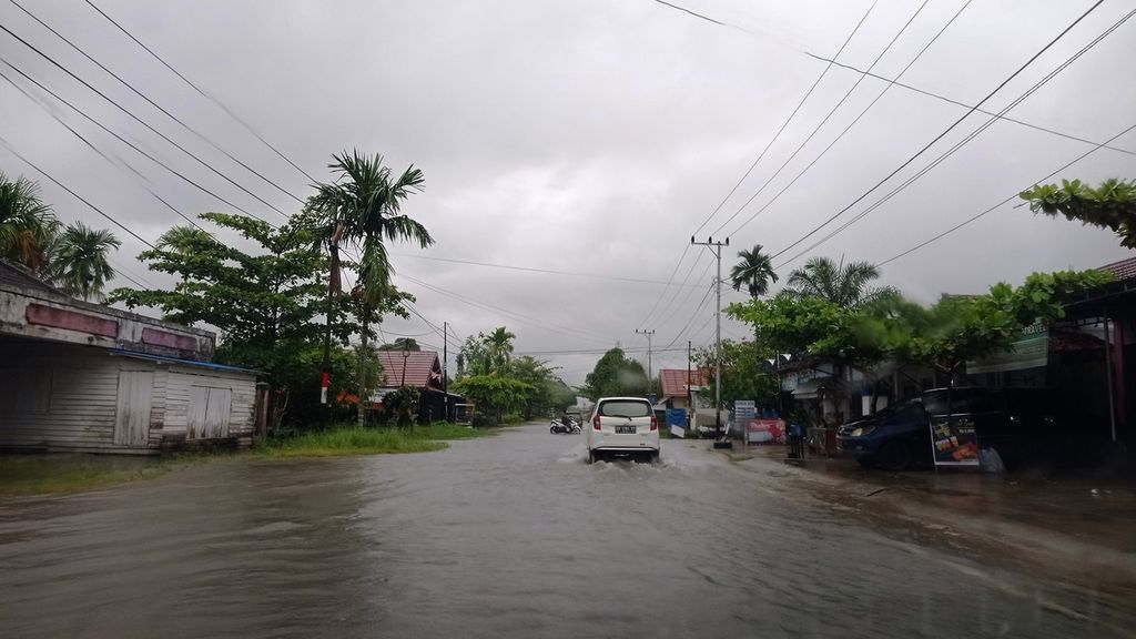 Luapan air dari drainase yang mampet menggenangi Jalan Tingang, Kota Palangkaraya, Selasa (19/4/2022).