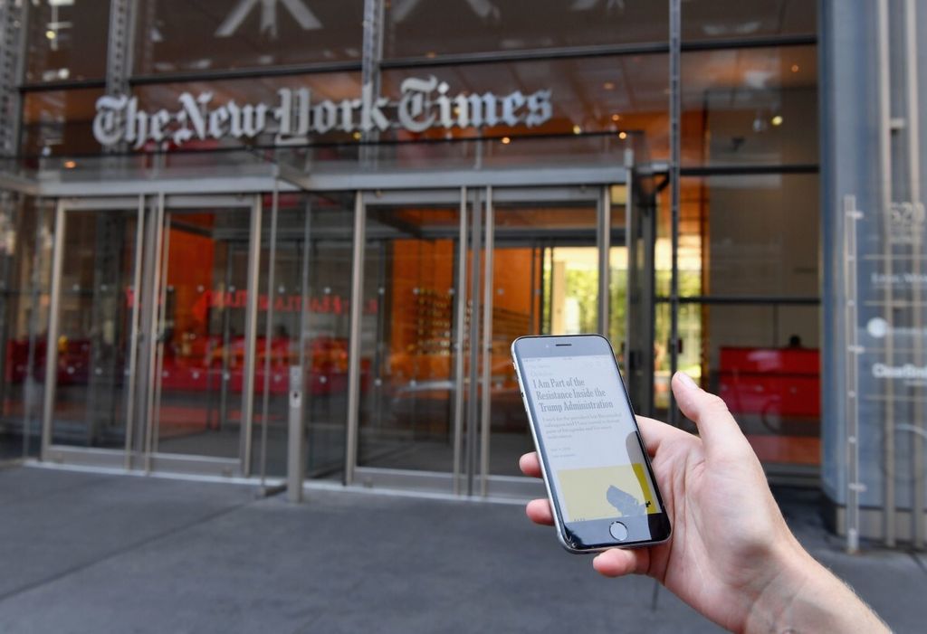 Sebuah ponsel dipegang dalam ilustrasi di depan gedung New York Times pada 6 September 2018 di New York, AS.
