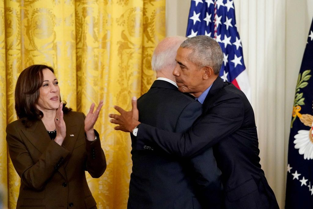 Wakil Presiden AS Kamala Harris (kiri) memberikan aplaus, sementara Presiden AS Joe Biden (tengah) dan mantan Presiden AS Barack Obama berpelukan dalam sebuah acara di Ruang Timur Gedung Putih di Washington DC, AS, 5 April 2022. 