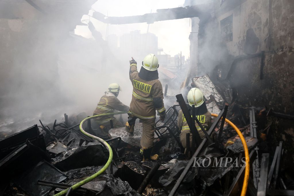 Para petugas pemadam kebakaran melakukan pendinginan di salah satu bangunan yang terbakar di Jalan Dr Saharjo, Kecamatan Setiabudi, Jakarta, Kamis (11/1/2024).