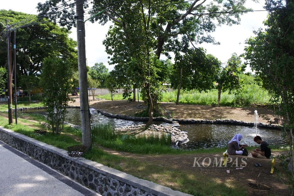 Pengunjung bersantai di tepi kolam air mancur di kawasan Taman Udayana, Kota Mataram, Nusa Tenggara Barat, Senin (15/1/2024). 