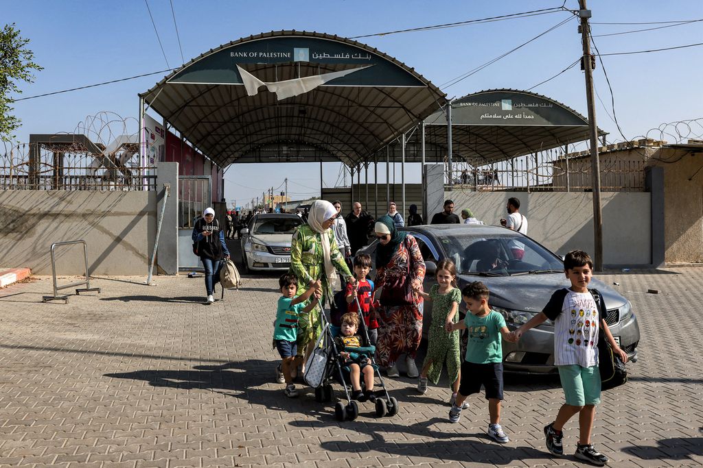 Orang-orang melintasi untuk masuk ke wilayah Mesir melalui Perbatasan Rafah di Jalur Gaza pada 1 November 2023. Perbatasan ini dibuka untuk pertama kalinya bagi perlintasan manusia sejak konflik dimulai 7 Oktober 2023. 